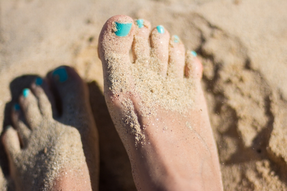 Tangan pantai pasir sepatu