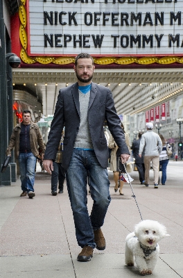 Man walking street dog Photo