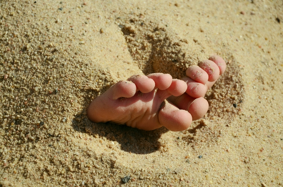 Mano spiaggia sabbia piedi