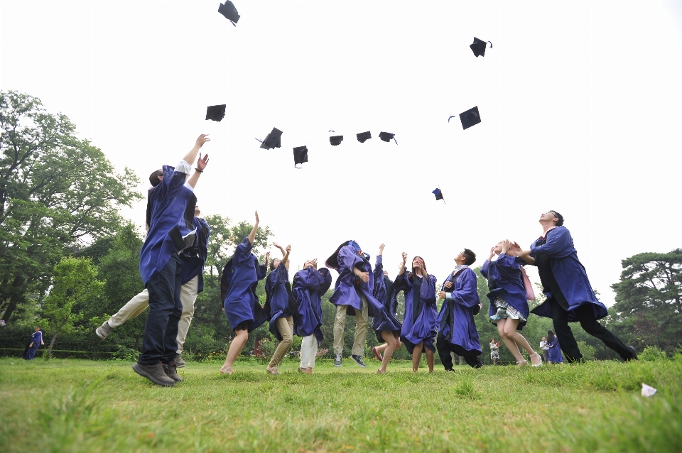 Gente saltando graduación sombreros