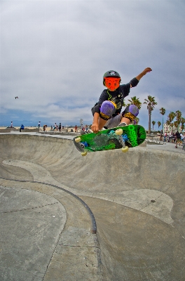 Foto Pasir skateboard anak laki-laki melompat