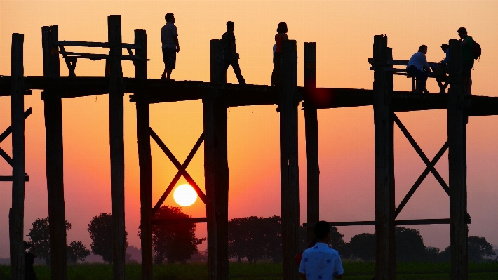 Foto Bayangan hitam rakyat matahari terbenam kaki langit