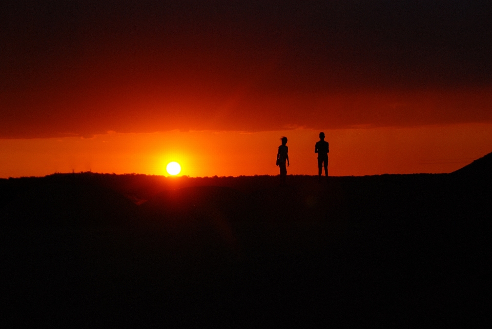 Orizzonte silhouette persone sole