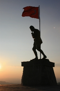 Foto Bayangan hitam matahari terbenam monumen patung