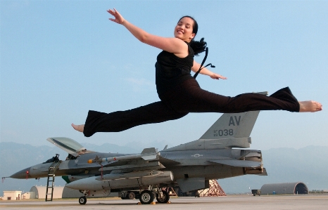 Woman jump airplane tarmac Photo