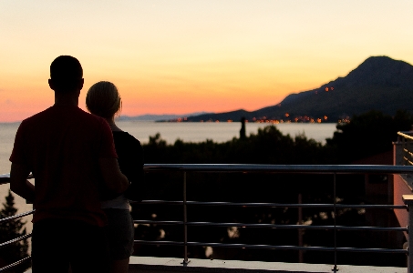 Silhouette people sunset balcony Photo