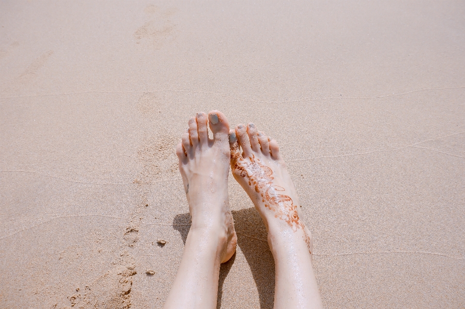 Main sable chaussure blanc