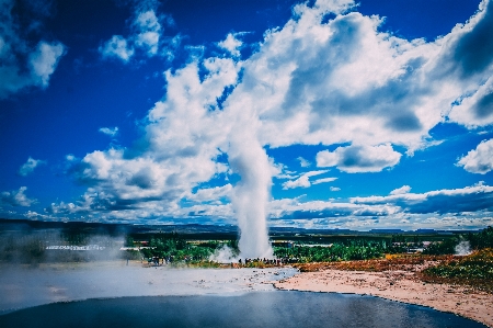 Geyser water clouds blue Photo