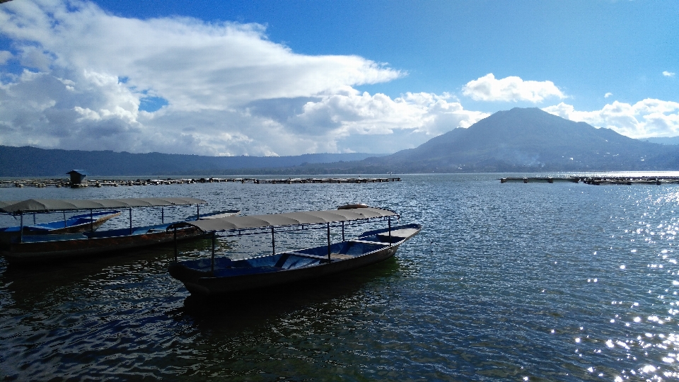 Lago vulcão barco ensolarado