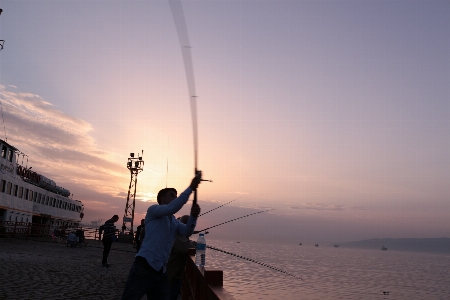 Fishing guy sea sunset Photo