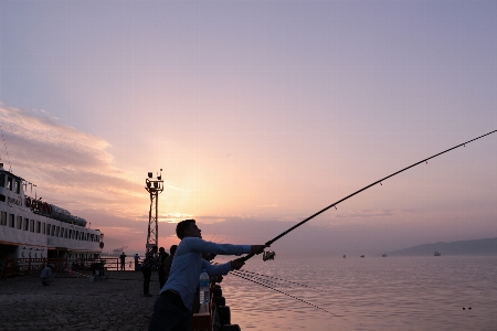 Fishing guy sea sunset Photo