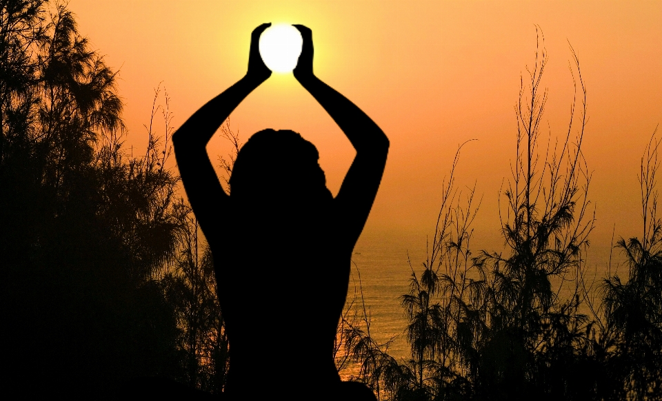 Yoga sun meditation holding sunset