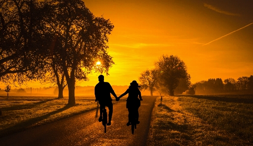 Sunset couple bicycle dating Photo