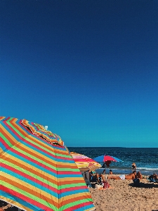 Beach people on umbrella sun tanning Photo