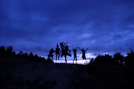 Friends silhouette blue jump Photo