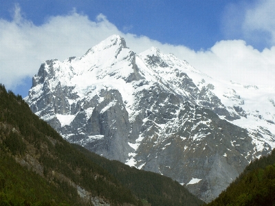 Snowy rocks clouds sky mountain Photo