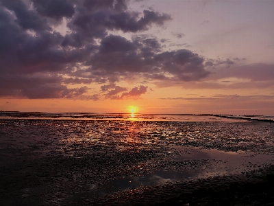 Foto Pôr do sol nublado praia laranja