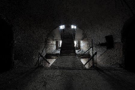 Urban exploration tunnel stones light darkness monochrome black and white Photo