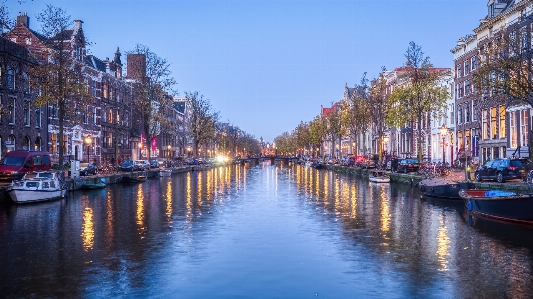 Canal buildings boats trees Photo