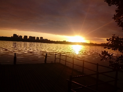 Foto Matahari terbenam laguna
 air awan