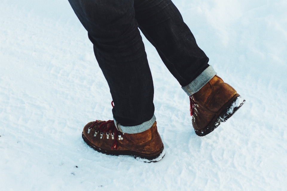 Mão andando sapato neve