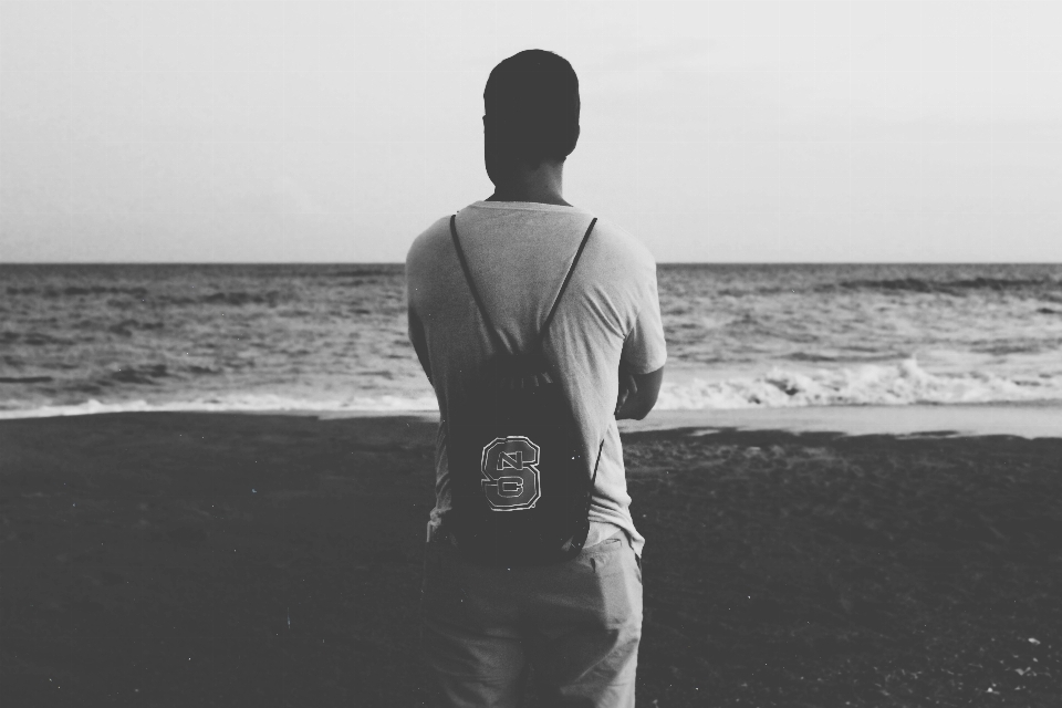 Uomo spiaggia mare bianco e nero
