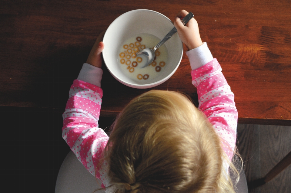 Mano cabello niño desayuno